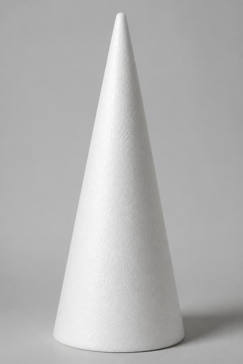 Pyramide conique en polystyrène blanc à base circulaire, posée verticalement sur une surface plane, avec un éclairage latéral soulignant sa hauteur.