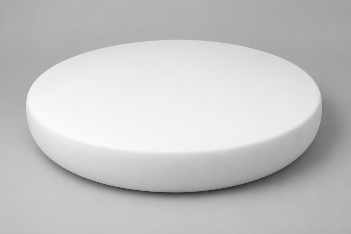 Forme blanche large et basse en polystyrène, surface lisse, vue de trois quarts sur fond neutre, silhouette circulaire visible depuis le dessus.